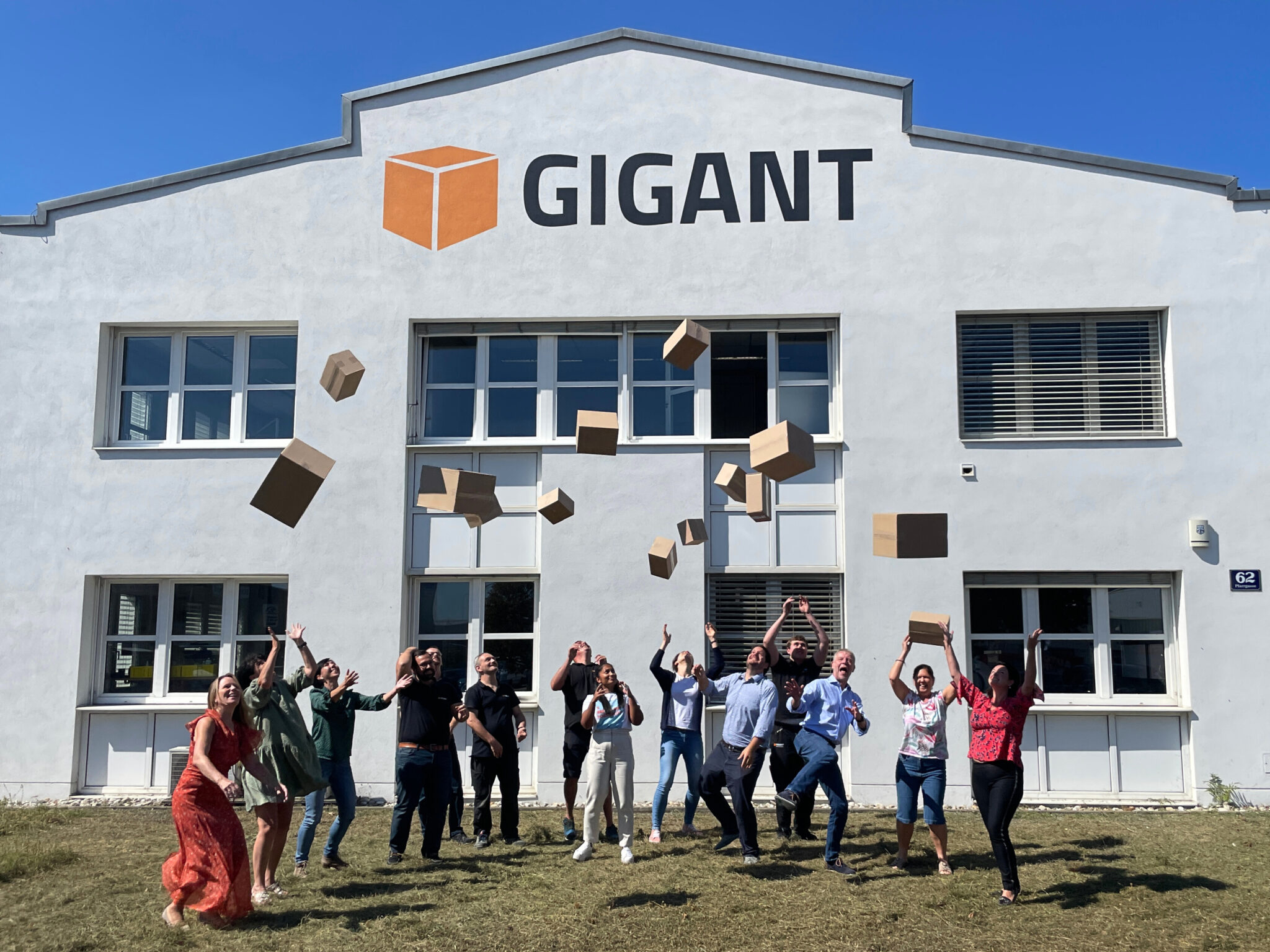 GIGANT Mitarbeiter werfen Kartons in die Luft